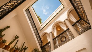A multi-level atrium with cacti, a skylight, and ornate iron railings. - Riad Belvi - Breakfast - 10mn Jemaa El Fnaa-Pool (Marrakech)