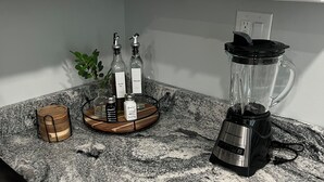 Eine Küche mit weißen Schränken, einer Granitarbeitsplatte, einem Mixer und einem Toaster.