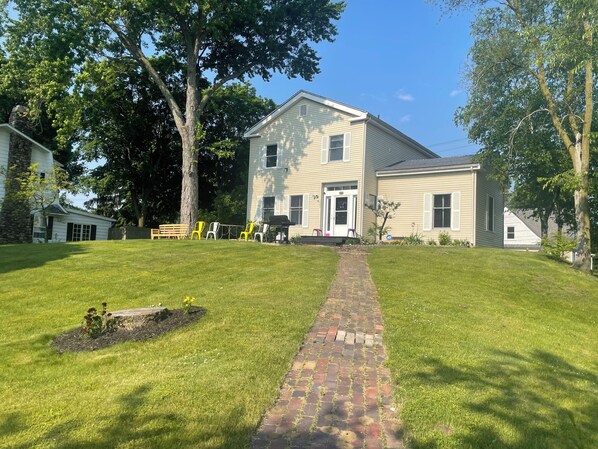 A two-story house with a brick pathway leading to the front door.