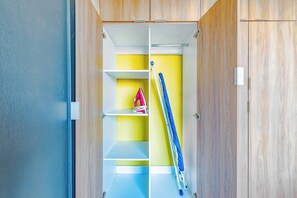 A closet with wooden doors, a blue and white ladder, and a yellow shelf. - Hermoso Depa en Centro Historico | Mini split (Durango)