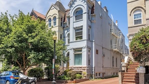 A historic building with a corner entrance, large windows, and a brick facade. - Cozy 1-bedroom apartment located in UNBEATABLE location Washington DC (Washington)
