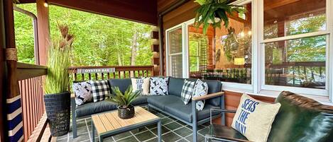 A cozy outdoor seating area with a sofa, armchairs, and a coffee table.