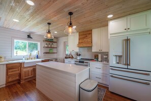 A modern kitchen with wooden cabinets, white countertops, and stainless steel appliances. - Breathtaking farmhouse with 4 bedrooms, Fishing, Kayaking, 6 acre pond! (Shickshinny)