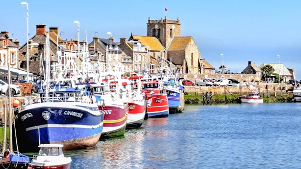 A harbor with boats docked along the waterfront, a church with a tower, and buildings with chimneys. - Stunning home in La Pernelle with WiFi (La Pernelle)