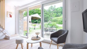 A modern living room with a large sliding glass door leading to an outdoor patio area. - Stunning home in La Pernelle with WiFi (La Pernelle)