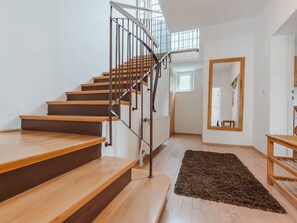 Una escalera de madera con barandillas de metal que sube a un piso superior.