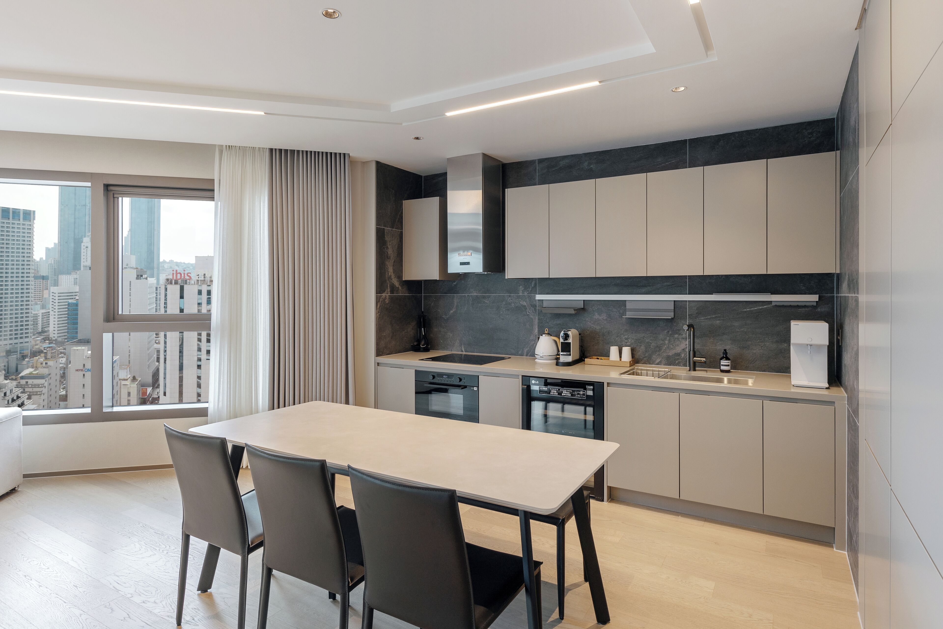 Una cocina moderna con una isla grande, electrodomésticos integrados y vistas a la ciudad.