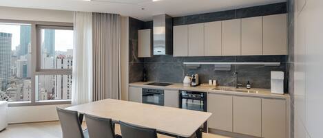Una cocina moderna con una isla grande, electrodomésticos integrados y vistas a la ciudad.