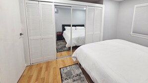 A bedroom with a bed, a wardrobe, and a nightstand.