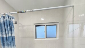 A bathroom with a bathtub, a window, and a shower curtain.