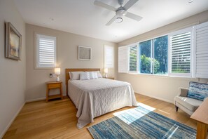 A bedroom with a bed, nightstands, a ceiling fan, and large windows. - Brunswick Lux - Close to Creek & Beach (Brunswick Heads)