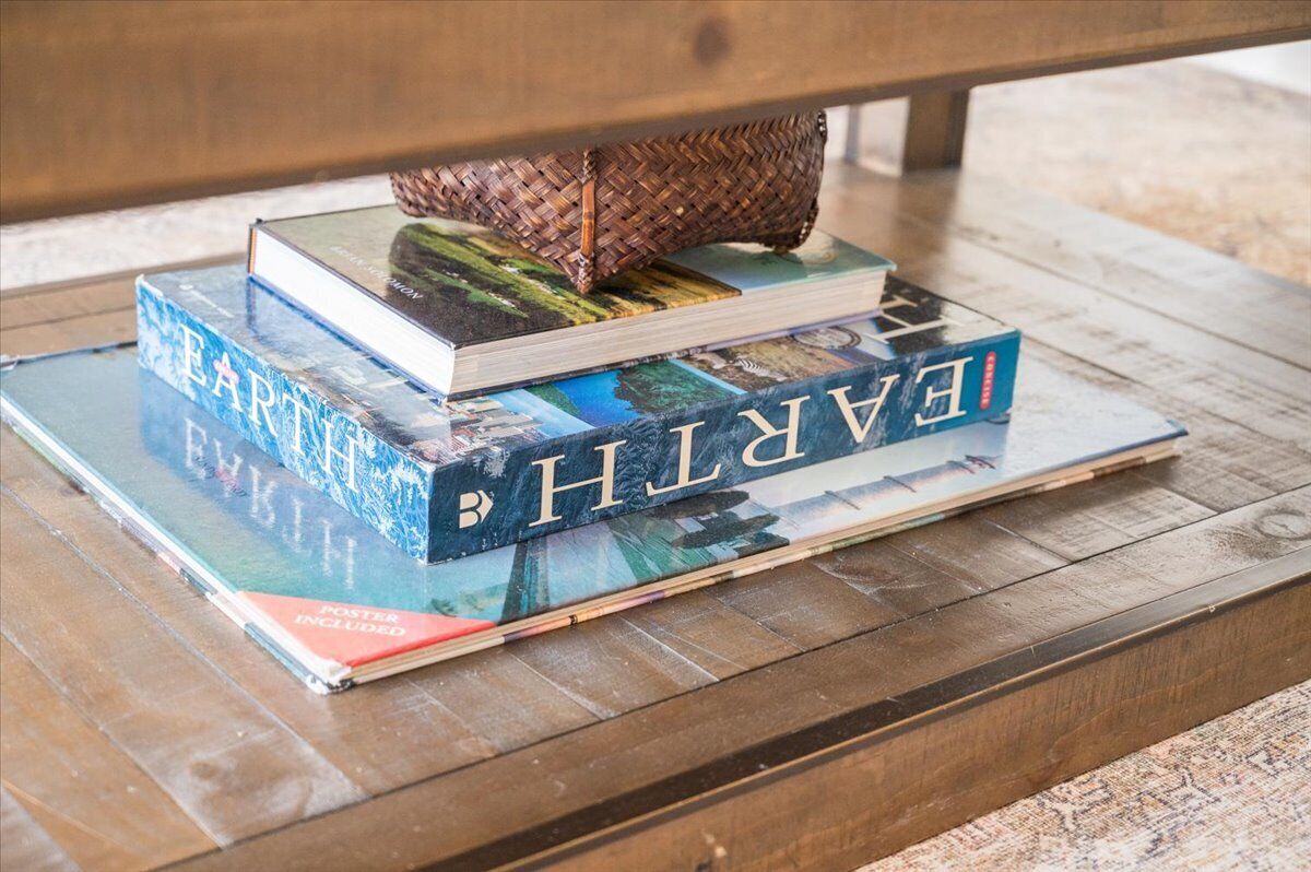 A stack of books on a wooden table.