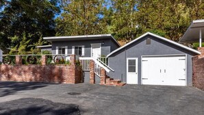 A modern two-story house with a garage, a brick wall, and a staircase leading to the upper floor.