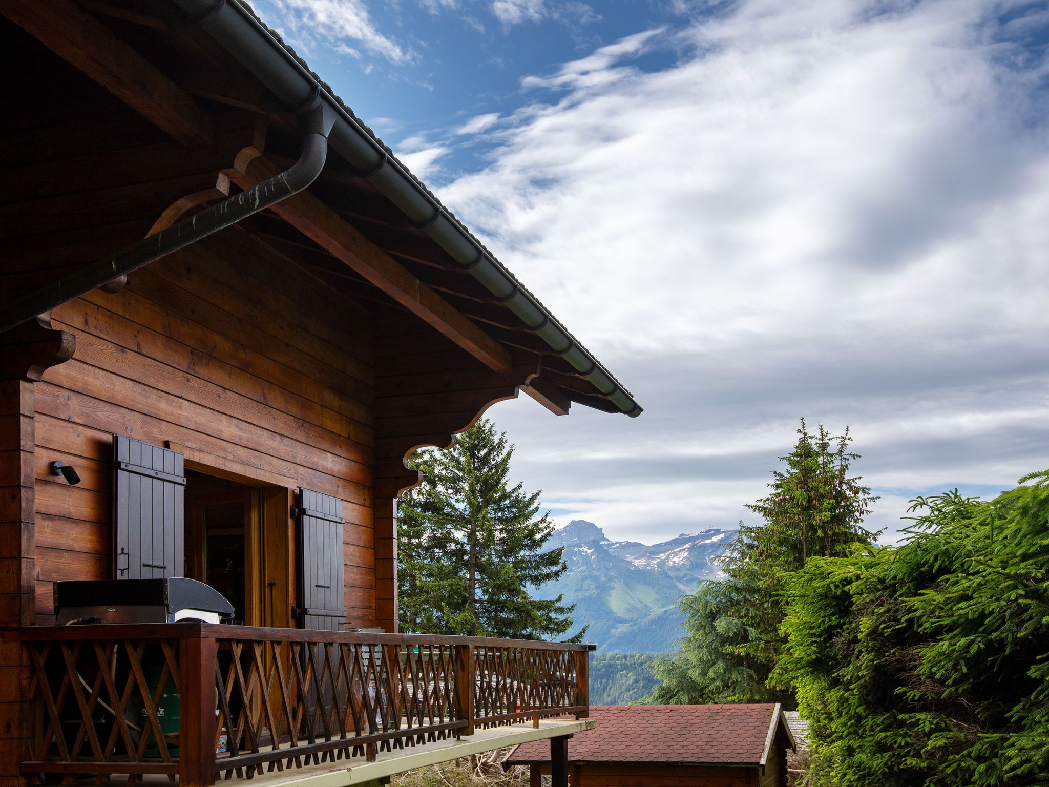 Eine Holzhütte mit einem Balkon mit Blick auf eine Berglandschaft.