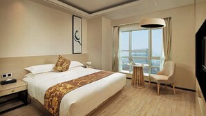 A hotel room with a large bed, a desk, a chair, a TV, and a large window with a view of the city. - Shanghai StarChain New Space Time Hotel (Zhongshan Park Subway Station) (Shanghai)