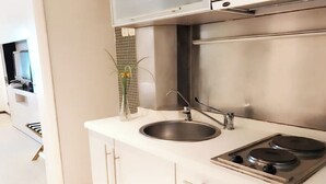 A modern kitchen with a stainless steel stove, a sink, and a small plant on the counter. - Shanghai StarChain New Space Time Hotel (Zhongshan Park Subway Station) (Shanghai)