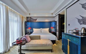 A hotel room with a large bed, a bedside table with a red lamp, a sofa, and a decorative wall with artwork. - StarChain Xixi Hotel (Xixi Wetland North Subway Station) (Hangzhou)