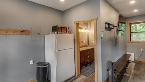A compact kitchen with a refrigerator, a microwave, and a sink with wooden cabinets. - Cabin w/Bunk on Whitefish Chain! (Crosslake)