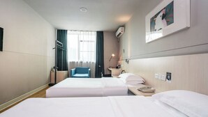 A hotel room with two beds, a desk, a chair, a window with curtains, an air conditioning unit, and a framed picture on the wall. - StarChain Qijiang Hotel - Zhongshan Xingzhong Square Sunwen Pedestrian Street Branch  (Zhongshan)