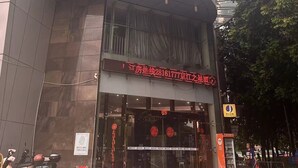A modern building with a curved glass facade and a sign in Chinese characters. - StarChain Qijiang Hotel - Zhongshan Xingzhong Square Sunwen Pedestrian Street Branch  (Zhongshan)