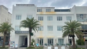A multi-story hotel with a modern facade, palm trees in front, and a sign indicating a restaurant and bar. - StarChain Ocean View Hotel (Shenzhen Yantian Seafood Street) (Shenzhen)