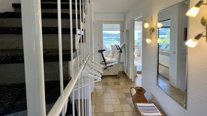 A staircase with a handrail, a view of a balcony with outdoor furniture, and a wall-mounted light fixture. - Seepanorama by Interhome (Öhningen)