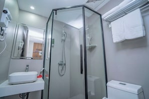 A modern bathroom with a glass-enclosed shower, a white sink, and a toilet.