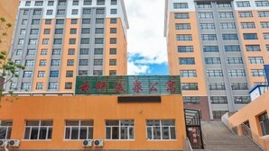 A multi-story building with a green signboard. - Hexigten Banner Yunxuan Hot Spring Homestay (Hexigten Banner)