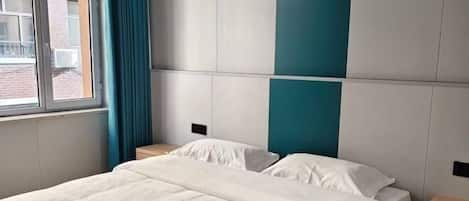 A hotel room with a bed, a window, and a view of the outside.