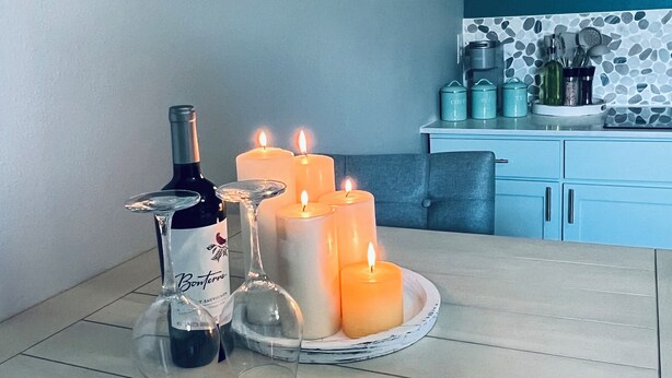 A dining table with candles and a wine bottle.