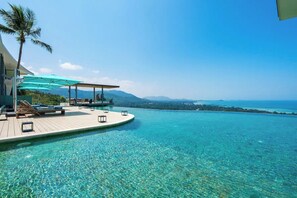 An infinity pool with clear water, a wooden deck, lounge chairs, and umbrellas. - 【Villa ME】Huge and Luxurious villa (Chang Wat Surat Thani)