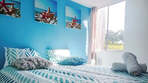 A bedroom with a bed, pillows, and a window with curtains. - Very natural, Peaceful and Centrally in Medellín (Envigado)