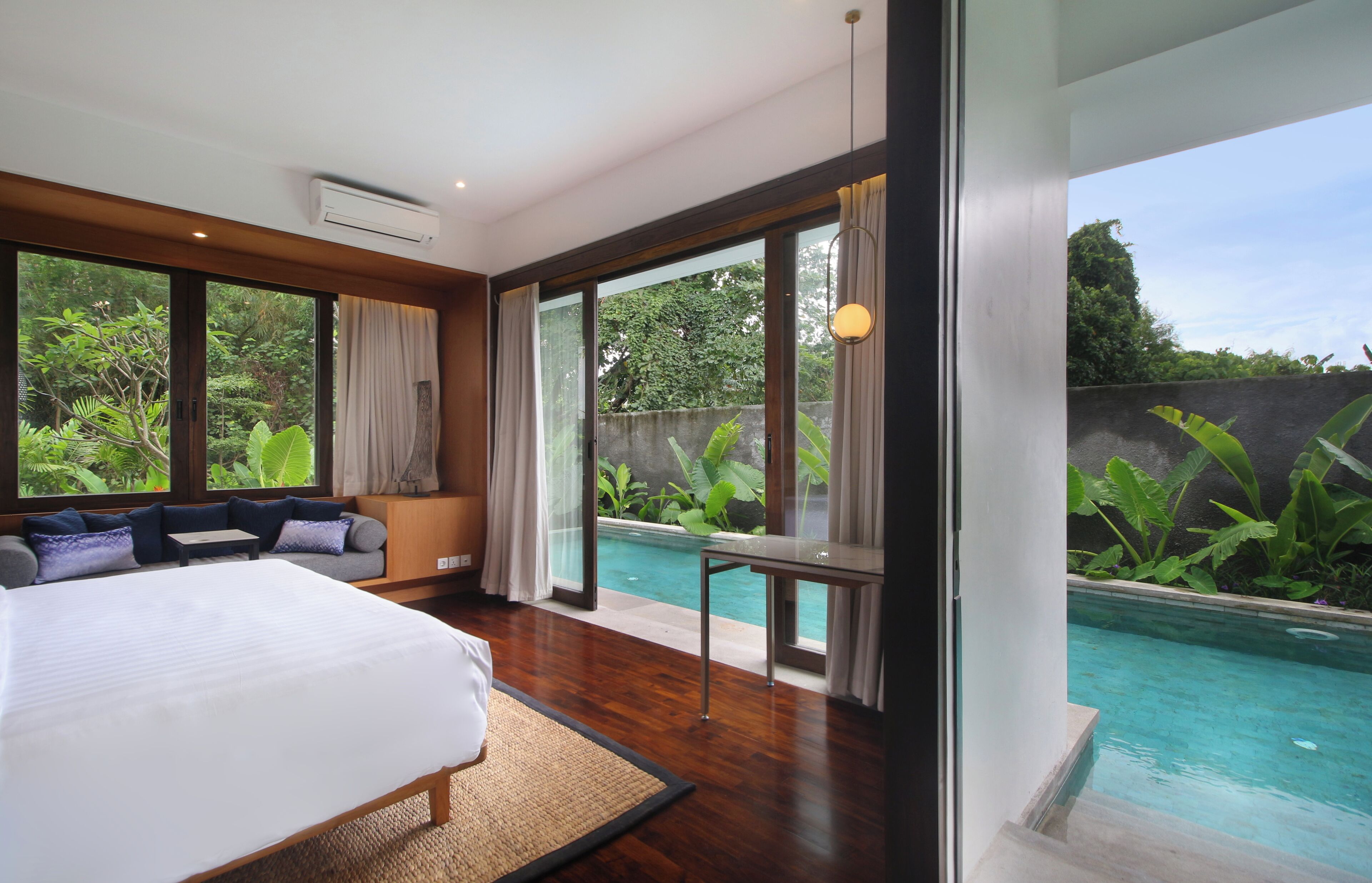 Une chambre avec un grand lit, un canapé et une vue sur une piscine.