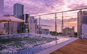 A rooftop pool with a view of the sea and cityscape at sunset. - Ocean View Nha Trang (Nha Trang)