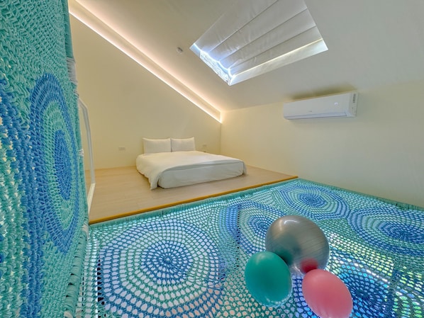 Een moderne slaapkamer met dakraam, een bed en een bijzondere mozaïektegelvloer.