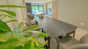 A modern meeting room with a long table, comfortable chairs, and a view of the outdoors. - Longtan Lake Inn (Jiaoxi)