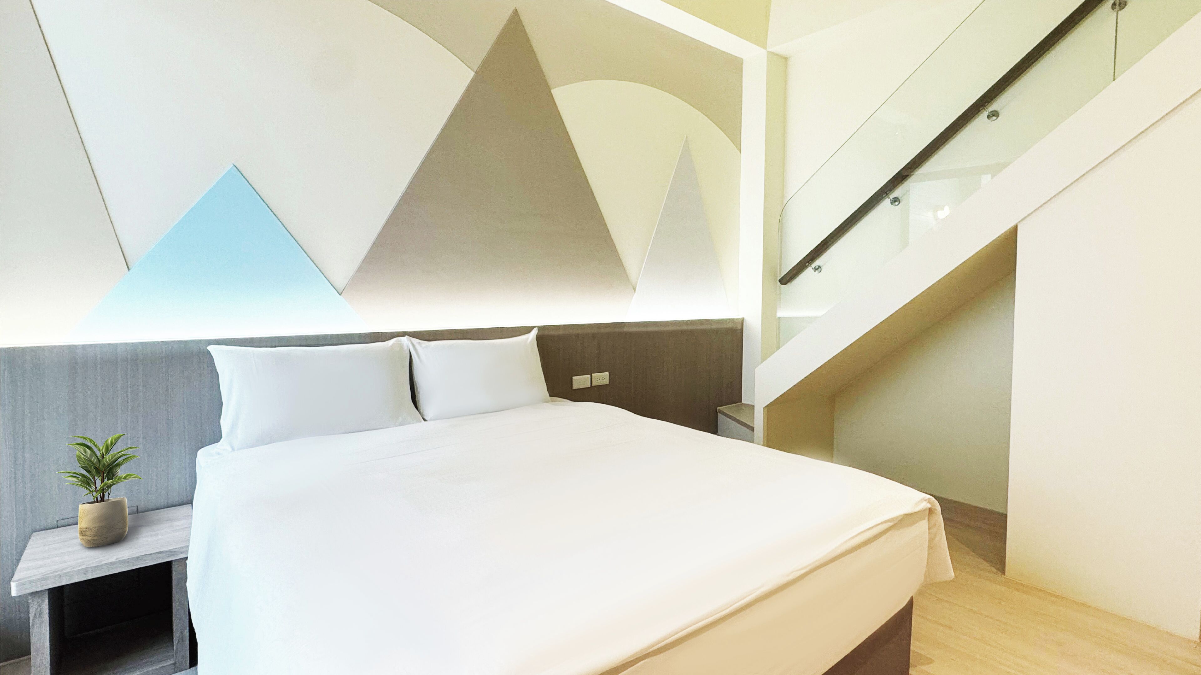 Una habitación de hotel moderna con una cama grande, una mesita de noche con una planta y una escalera.