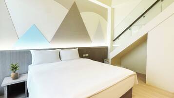 Una habitación de hotel moderna con una cama grande, una mesita de noche con una planta y una escalera.