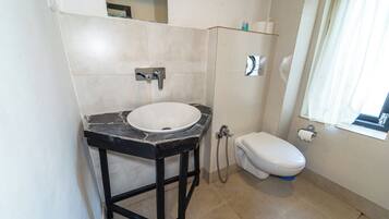 A bathroom with a white sink, black countertop, and a white toilet.