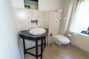 A bathroom with a white sink, black countertop, and a white toilet.