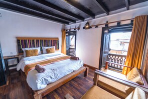 Une chambre à coucher avec un lit en bois, une table de chevet, une chaise et une fenêtre avec des rideaux.