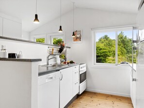 Kjøleskap, ovn, oppvaskmaskin og høy barnestol