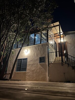 A modern building with a glass facade, a staircase, and a balcony.