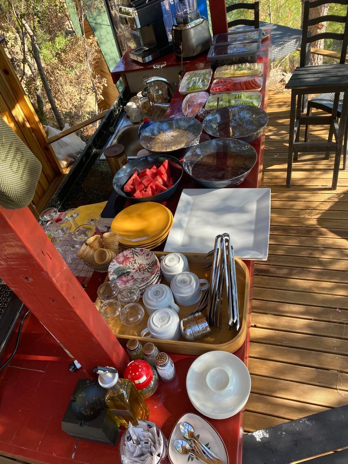 A picnic setup with a table set for a meal, including plates, bowls, and utensils.