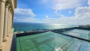 Ein Rooftop-Endlospool mit klarem, blauem Wasser mit Blick auf den Ozean.
