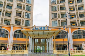 A hotel entrance with a covered entryway, large arched windows, and a central entrance.