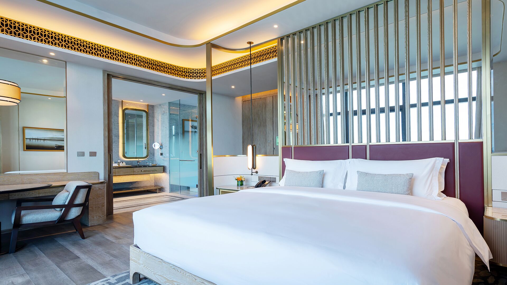 A modern hotel room with a large bed, a desk, a mirror, and a shower.