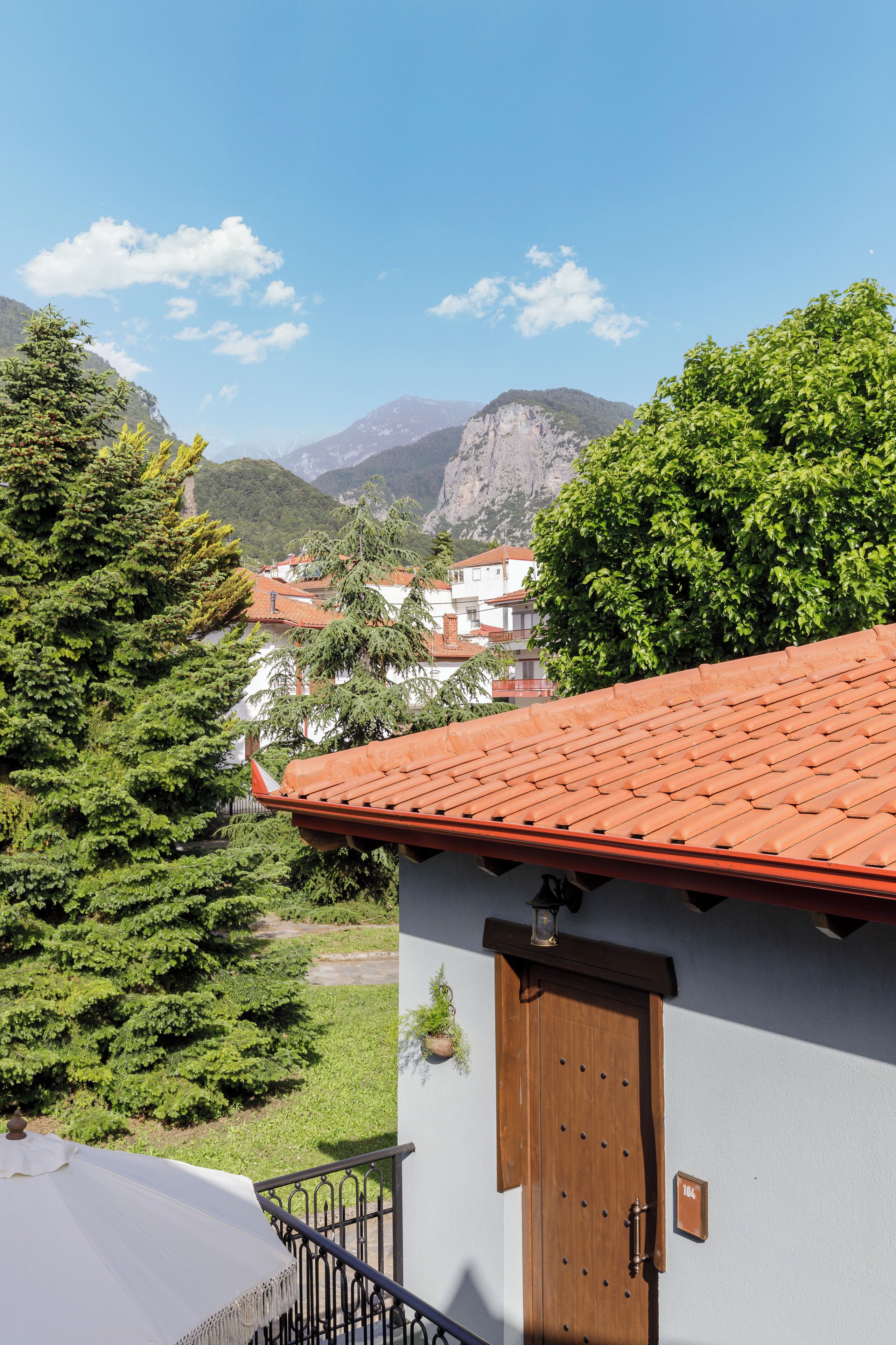 A building with a red-tiled roof, a wooden door, and a small balcony.