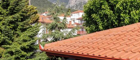 A building with a red-tiled roof, a wooden door, and a small balcony.