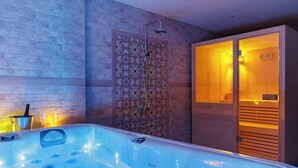 Une salle de bain moderne dotée d’une grande baignoire, d’un espace douche et d’un sauna.